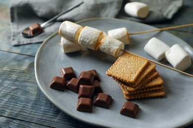Ingredients for delicious sandwich with roasted marshmallows and chocolate on grey wooden table, closeup