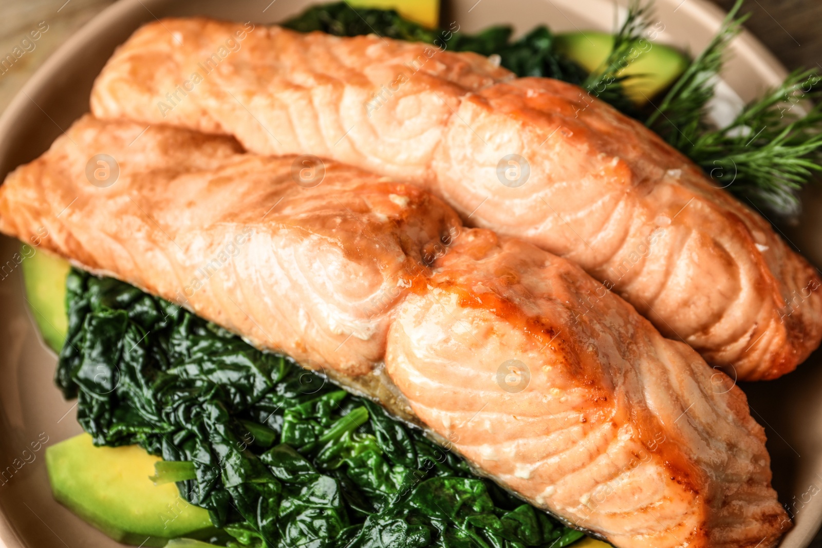 Photo of Tasty salmon with spinach and avocado on plate, closeup