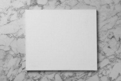 Photo of Blank canvas on white marble background, space for text