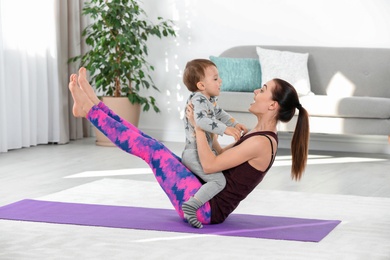Photo of Woman doing fitness exercises together with son at home