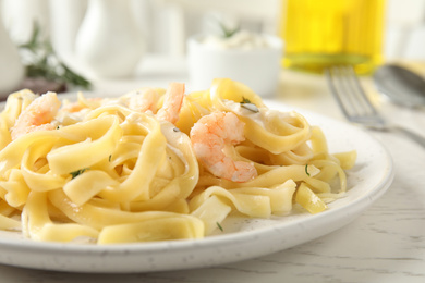 Photo of Delicious pasta with shrimps on white wooden table, closeup