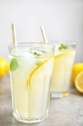 Glasses of cold lemonade on grey table