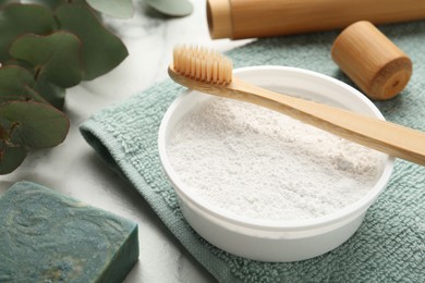 Tooth powder, brush and soap on white table, closeup