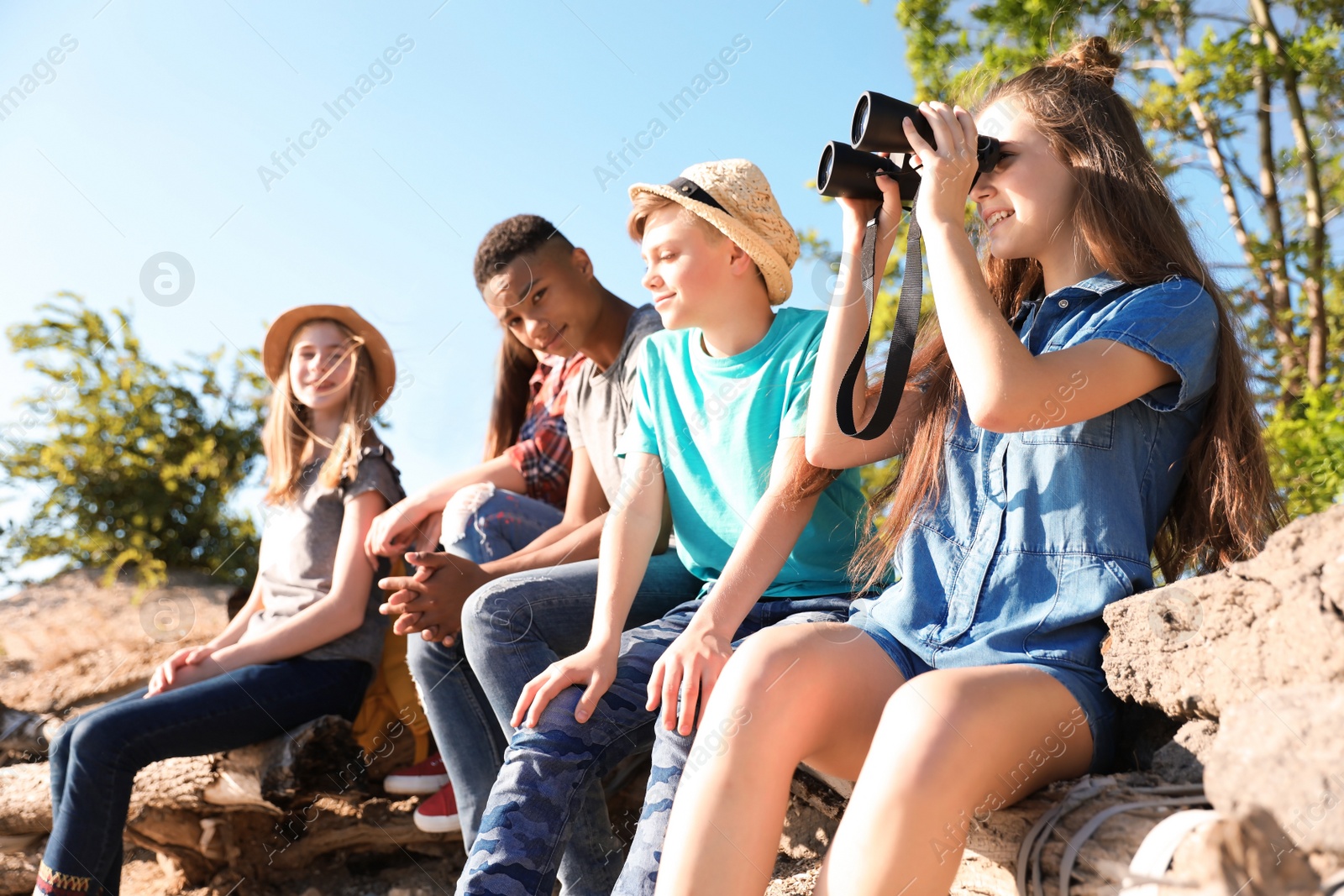 Photo of Group of children with binoculars outdoors. Summer camp