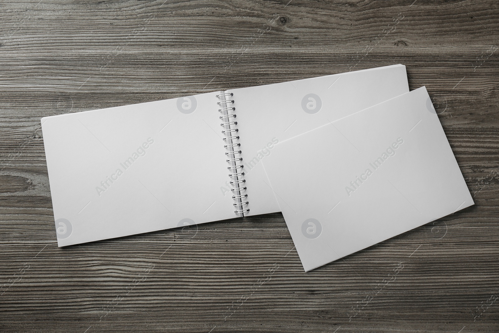 Photo of Sheet of paper and blank brochure on wooden table, flat lay. Mockup for design