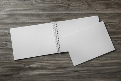 Photo of Sheet of paper and blank brochure on wooden table, flat lay. Mockup for design