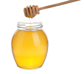 Glass jar of acacia honey and wooden dipper isolated on white
