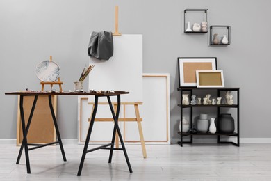 Photo of Artist's studio with easel, canvases and painting supplies