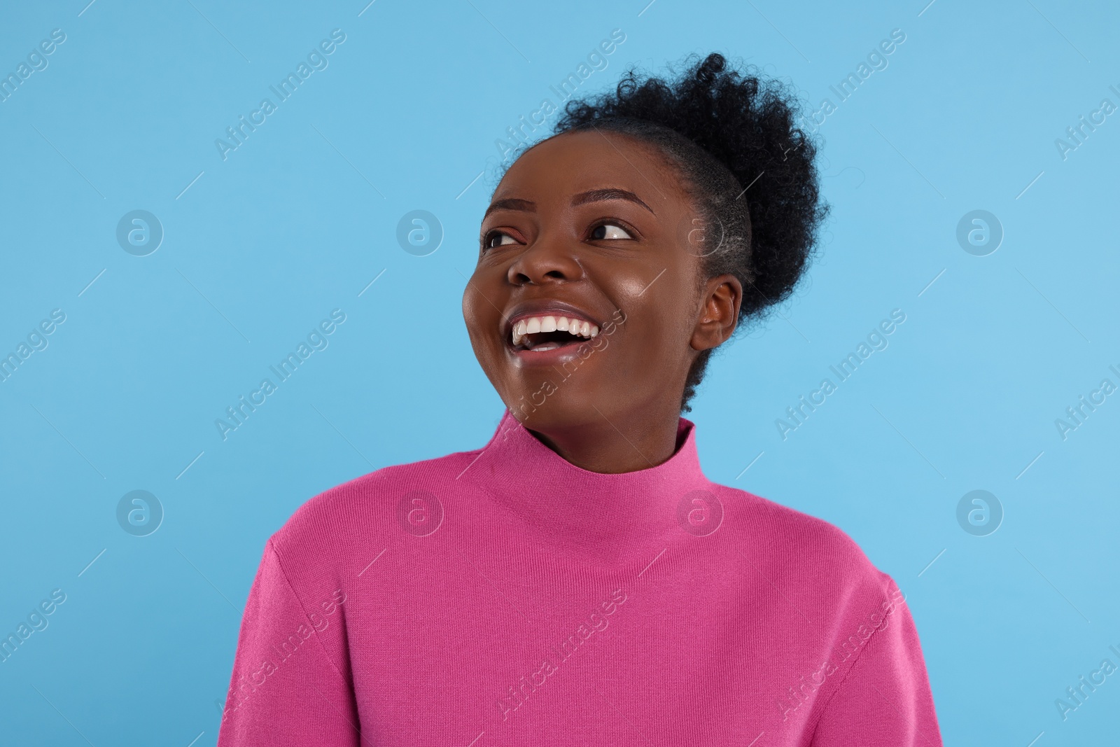 Photo of Portrait of happy young woman on light blue background