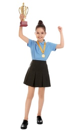 Photo of Happy girl in school uniform with golden winning cup and medal isolated on white