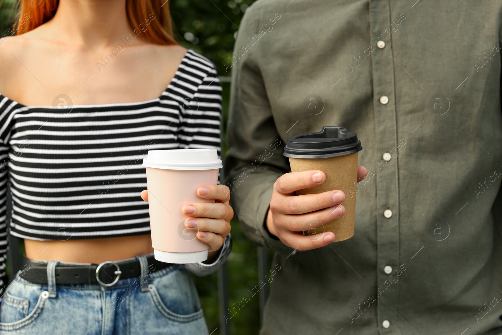 Photo of Coffee to go. Couple with paper cups outdoors, closeup