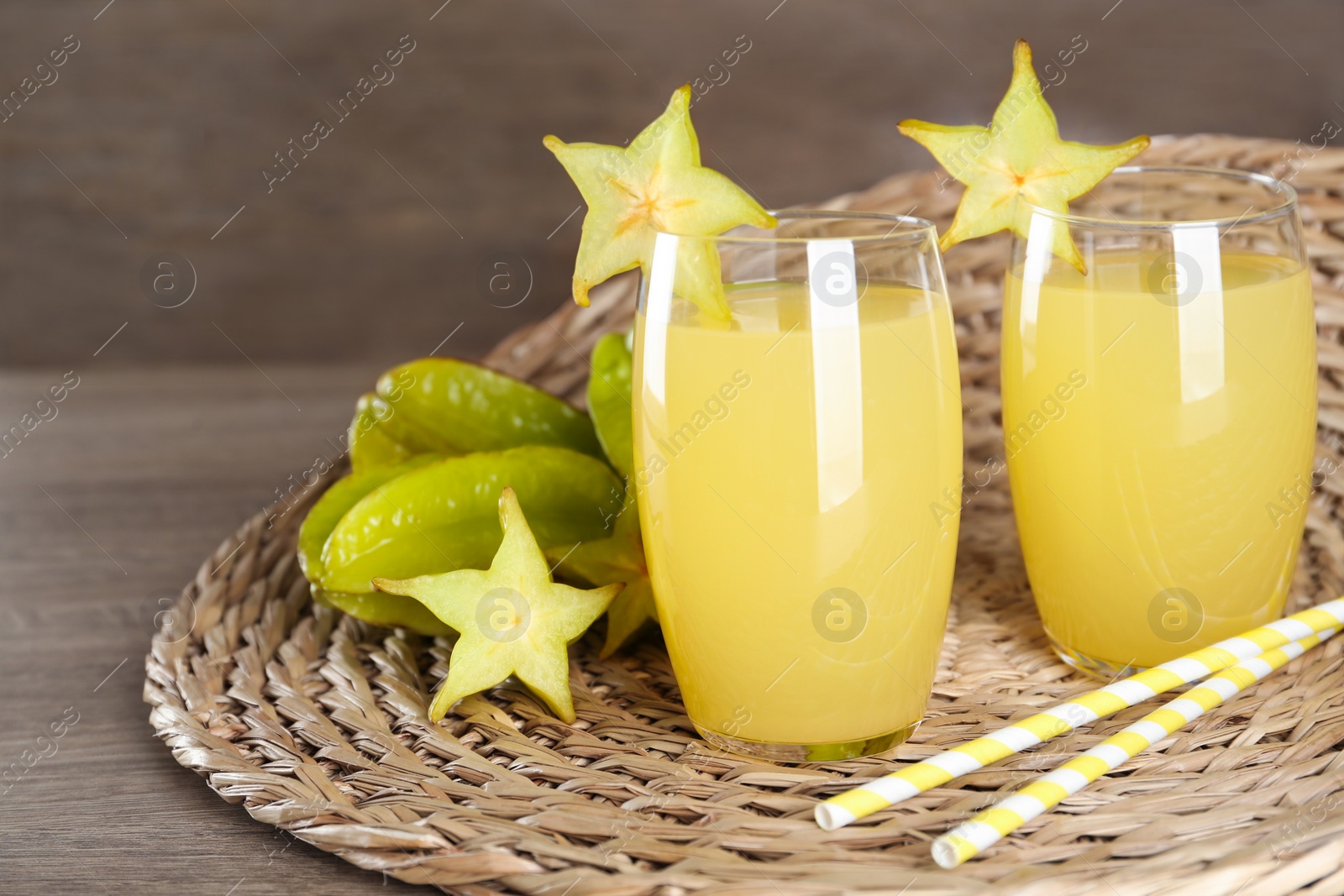 Photo of Delicious carambola juice and fresh fruits on wooden table. Space for text