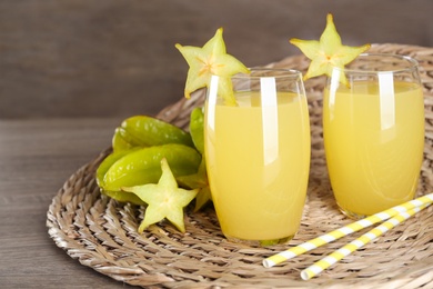 Delicious carambola juice and fresh fruits on wooden table. Space for text