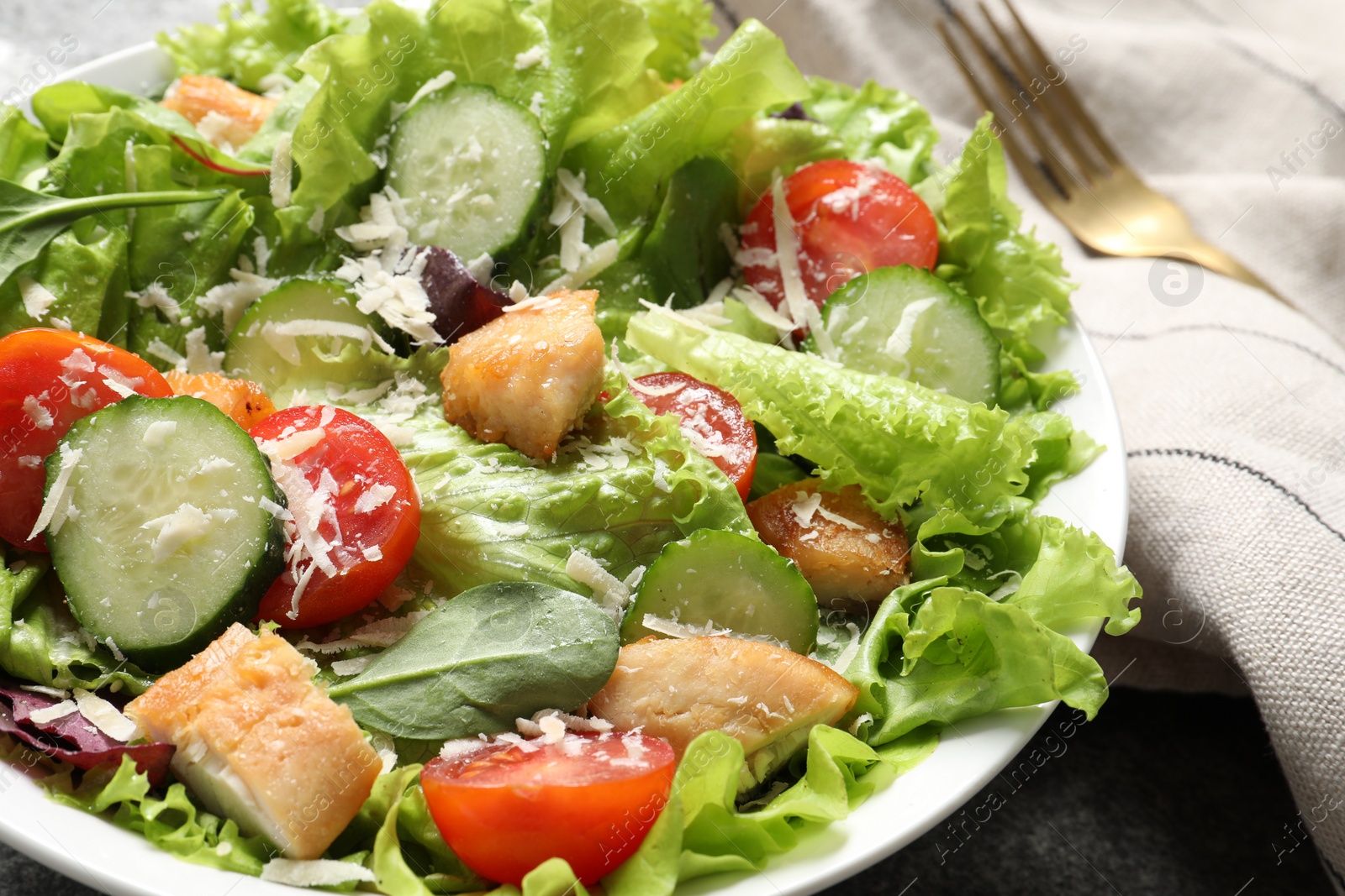 Photo of Delicious salad with chicken, cheese and vegetables on table, closeup