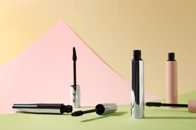 Photo of Different mascaras for eyelashes on color background