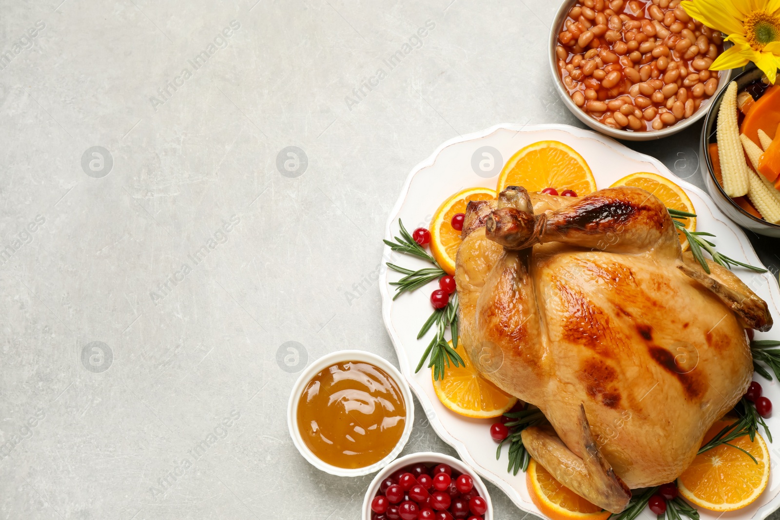 Photo of Traditional Thanksgiving day feast with delicious cooked turkey and other seasonal dishes served on grey table, flat lay. Space for text