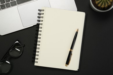 Photo of Flat lay composition with notebook and laptop on black table