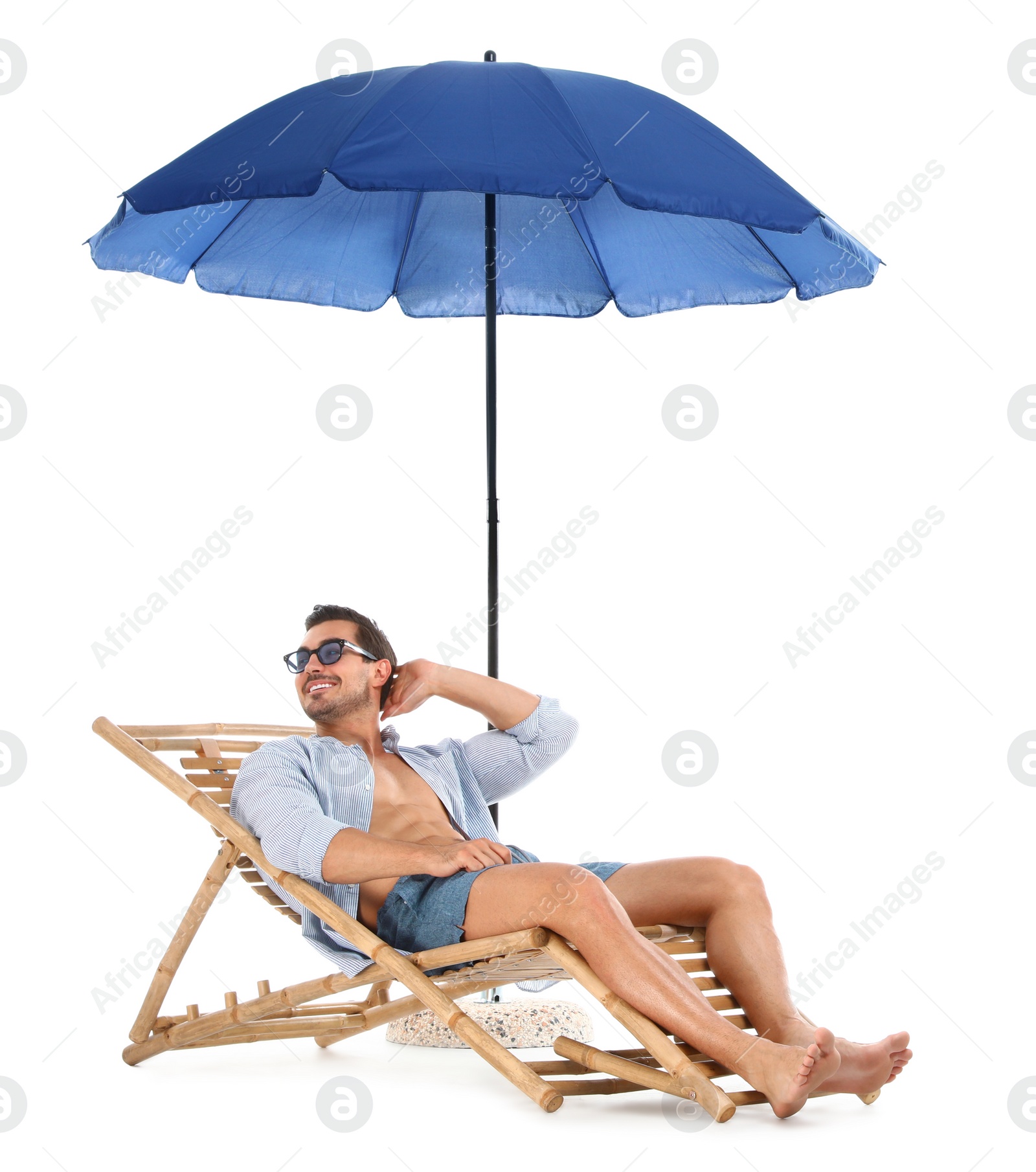 Photo of Young man on sun lounger under umbrella against white background. Beach accessories