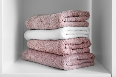 Stack of clean towels on shelf