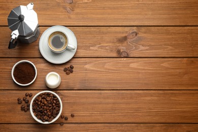 Photo of Flat lay composition with coffee grounds and roasted beans on wooden table, space for text