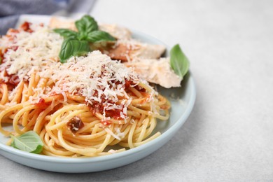 Photo of Delicious pasta with tomato sauce, chicken and parmesan cheese on white table, closeup. Space for text