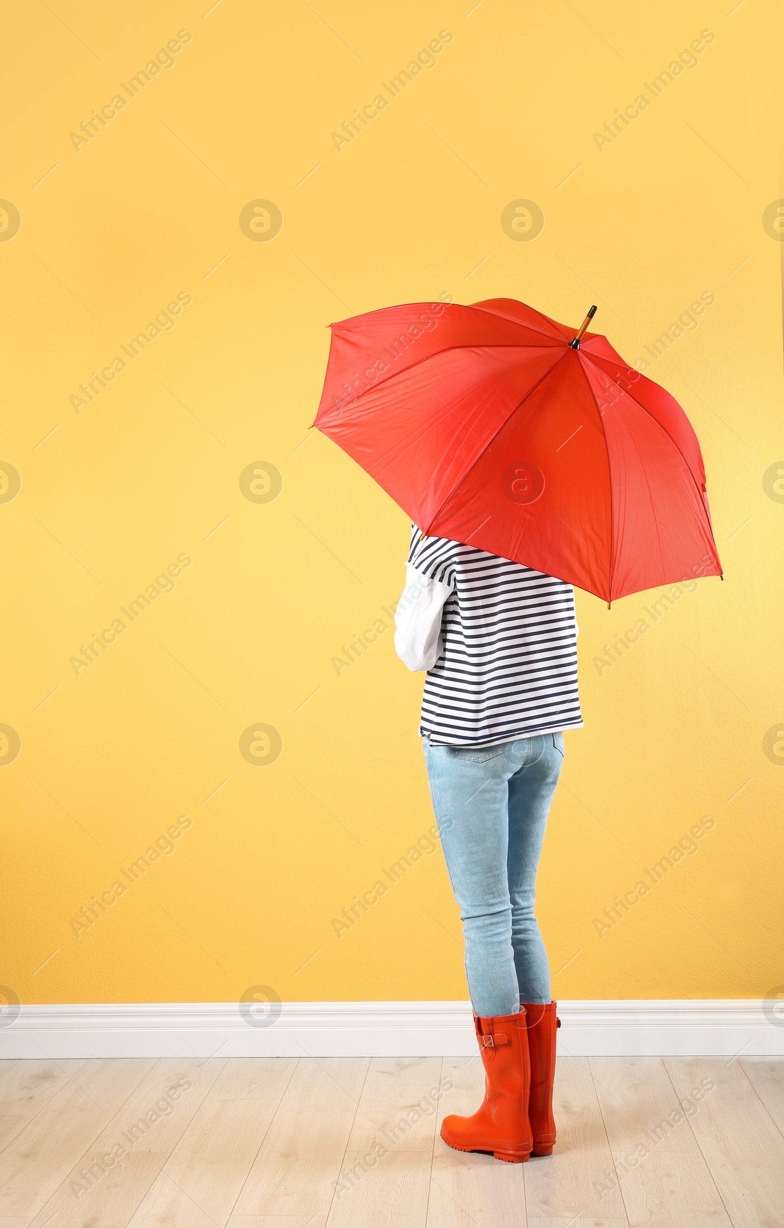 Photo of Woman with red umbrella near color wall