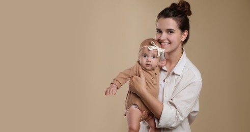 Beautiful mother with her cute baby on beige background, space for text. Banner design 