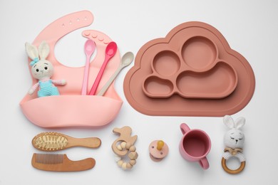 Composition with baby accessories and bib on white background, top view