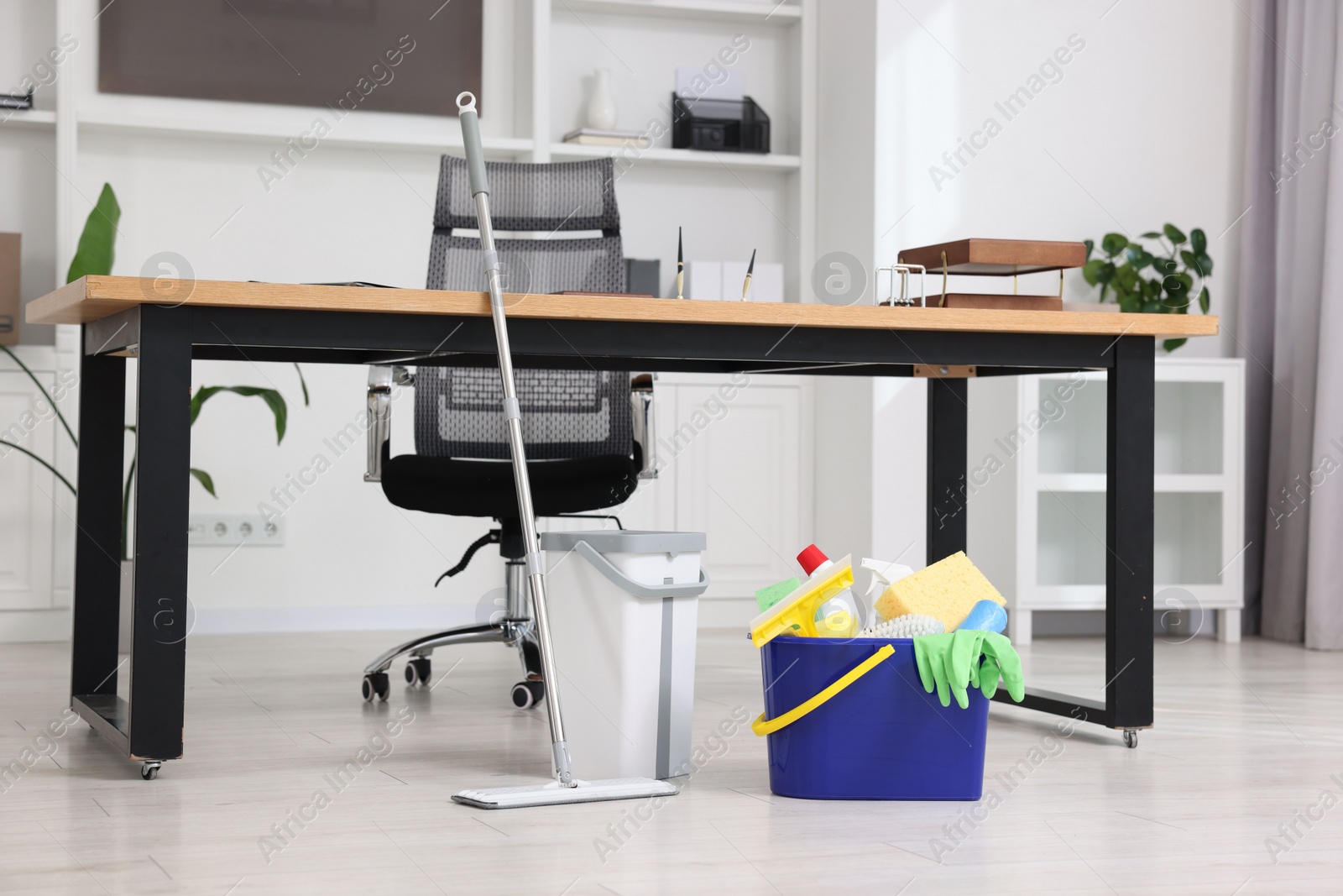 Photo of Cleaning service. Mop and buckets with supplies in office