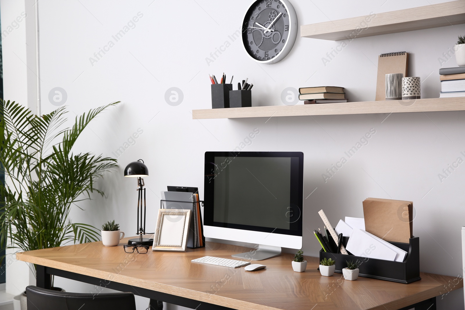 Photo of Modern computer on table in office interior. Stylish workplace