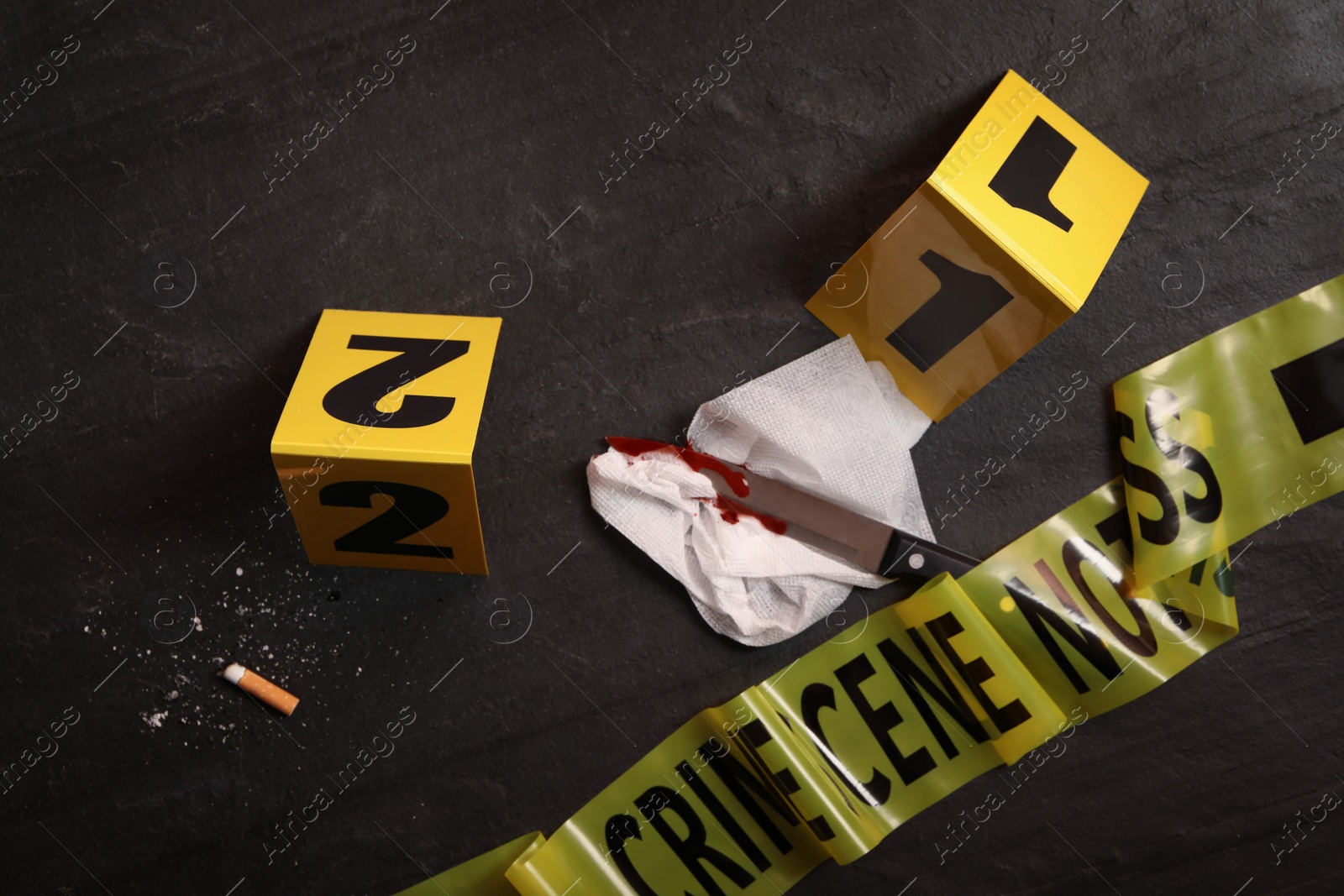 Photo of Flat lay composition with evidences and crime scene markers on black background