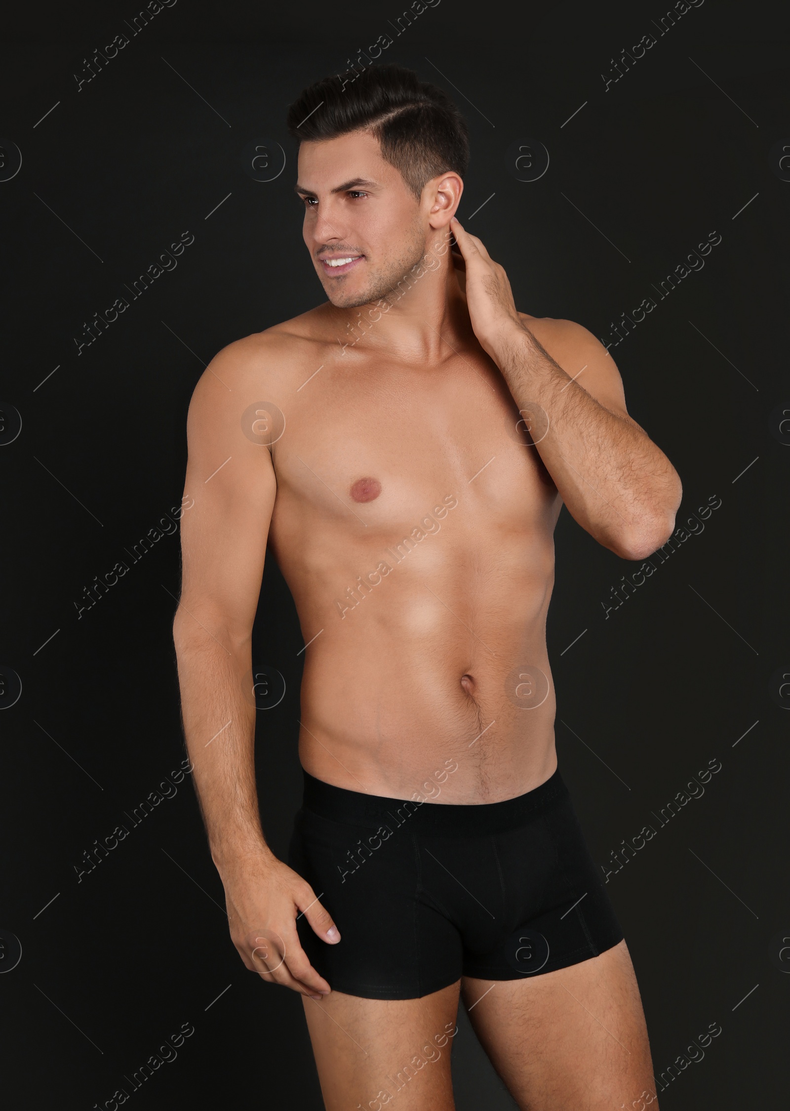 Photo of Handsome man in underwear on black background