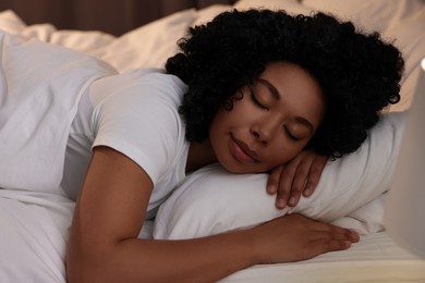 Photo of Young woman sleeping in soft bed at night