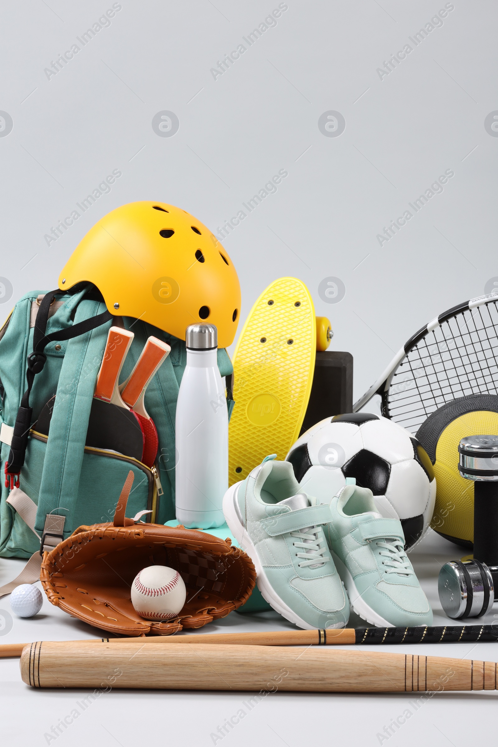 Photo of Many different sports equipment on light grey background