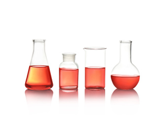 Photo of Different laboratory glassware with red liquid isolated on white
