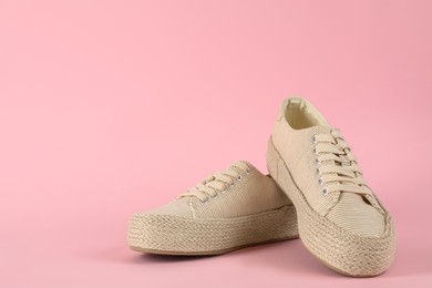 Photo of Pair of stylish sneakers on pink background. Space for text