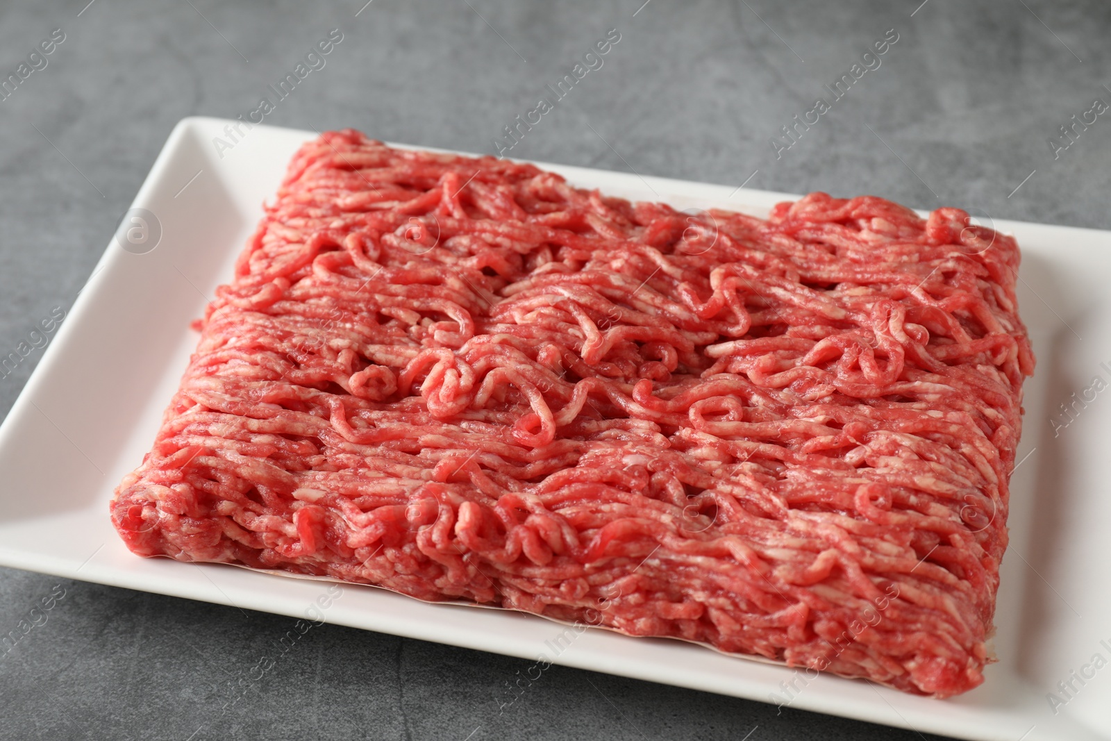 Photo of Raw ground meat on grey table, closeup