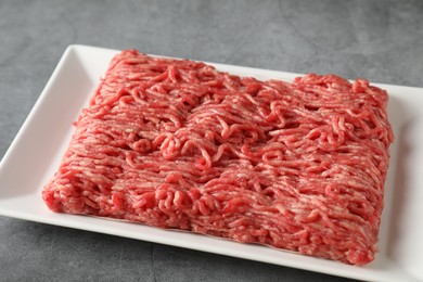 Raw ground meat on grey table, closeup