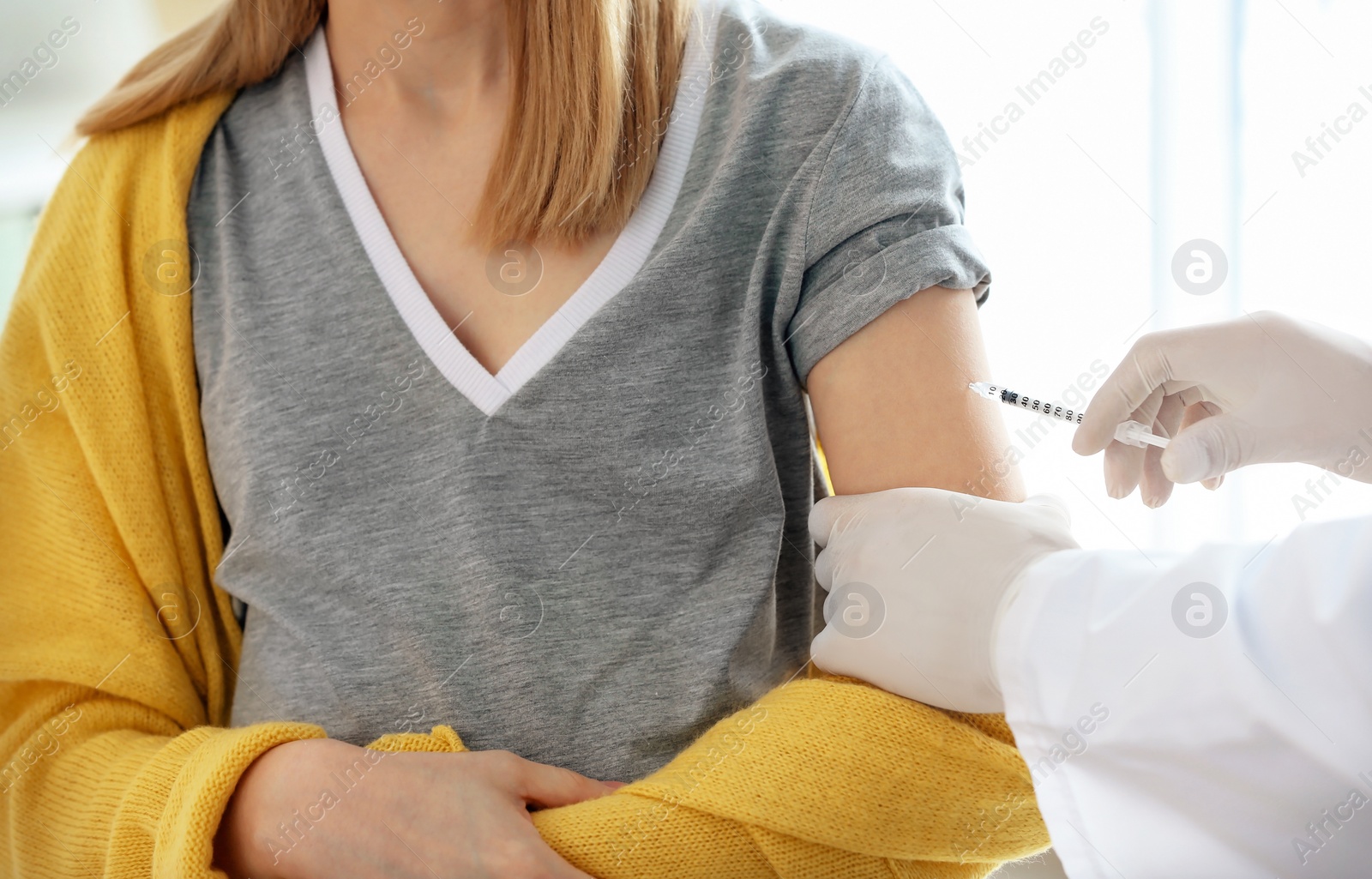 Photo of Doctor vaccinating female patient in clinic
