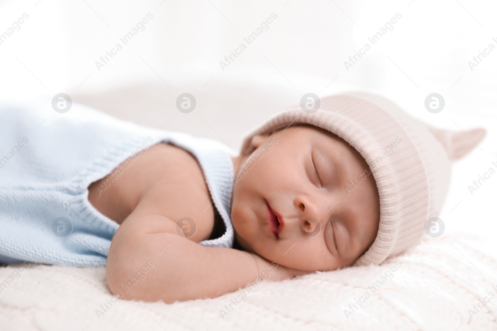 Photo of Adorable newborn baby sleeping on white knitted plaid