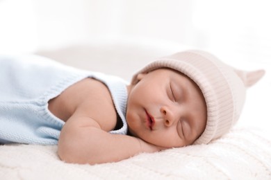 Photo of Adorable newborn baby sleeping on white knitted plaid