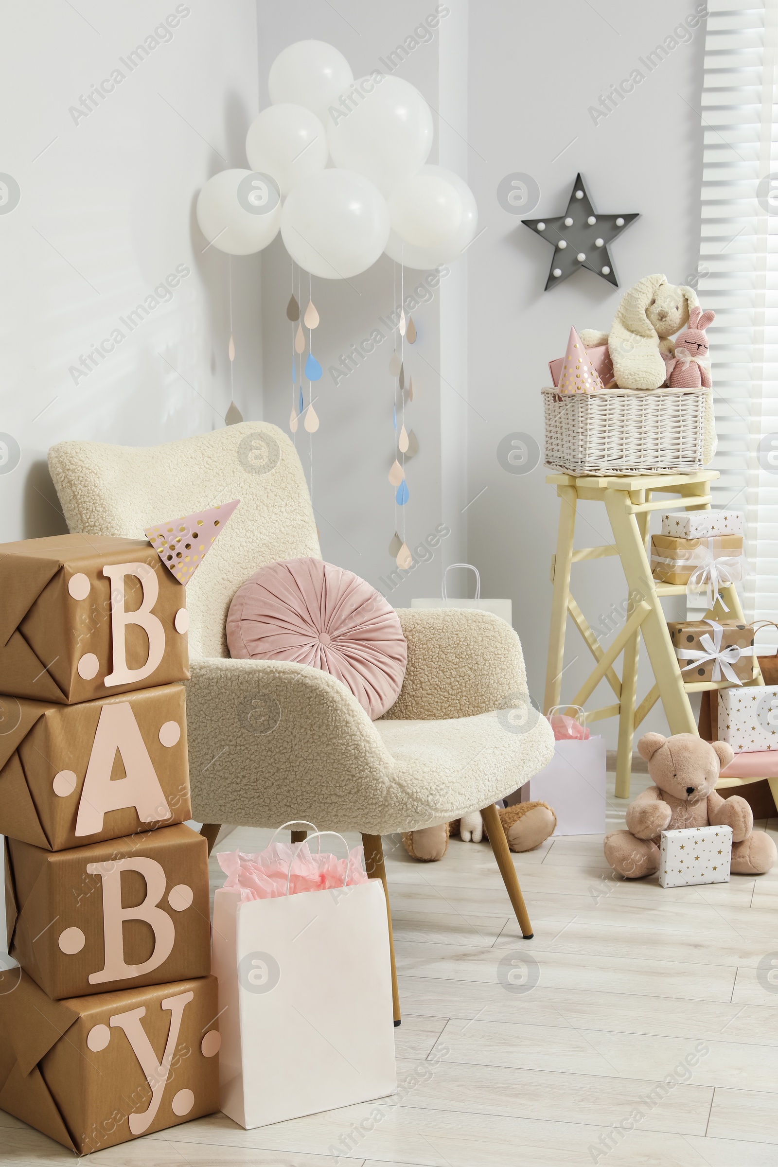 Photo of Baby shower party. Festive decor, gift boxes and toys in stylish room