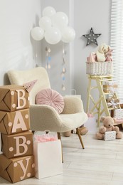 Photo of Baby shower party. Festive decor, gift boxes and toys in stylish room