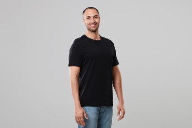 Man wearing black t-shirt on gray background