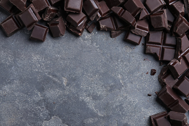 Photo of Delicious dark chocolate on light grey table, flat lay. Space for text