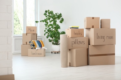 Photo of Cardboard boxes and household stuff indoors. Moving day