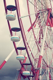 Image of Beautiful large Ferris wheel against heavy rainy clouds outdoors, closeup