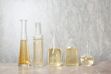 Photo of Row of different glass bottles with oil on color background