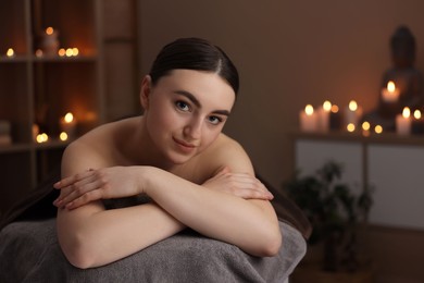 Photo of Spa therapy. Beautiful young woman lying on massage table in salon, space for text