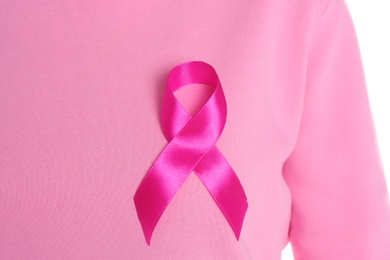 Photo of Woman with pink ribbon on white background, closeup. Breast cancer awareness